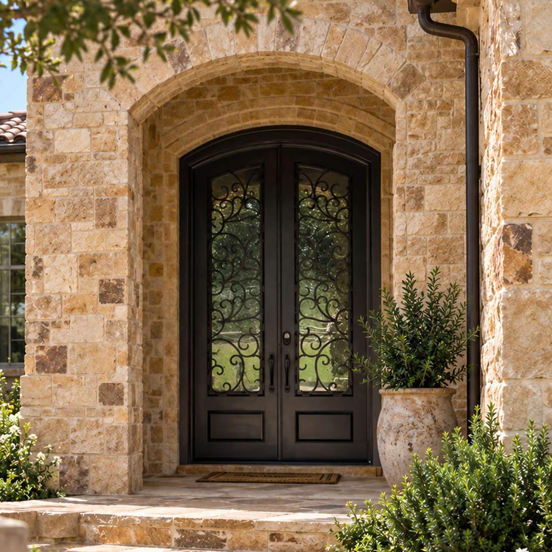 Single ornate black iron door at an arched stone entrance