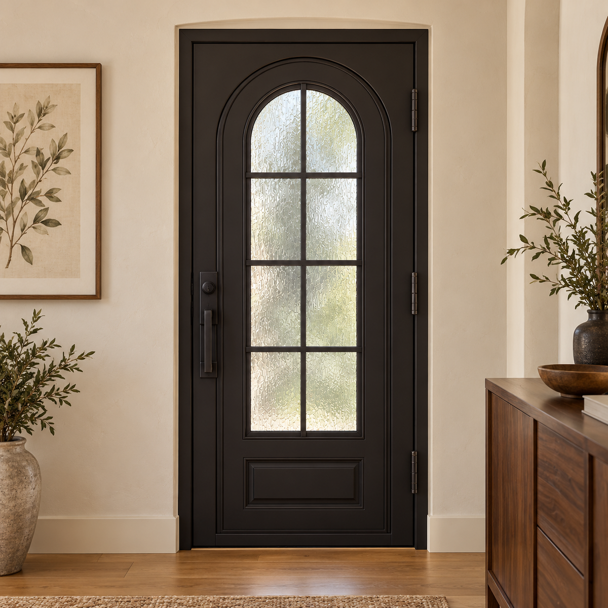 Interior view of a black iron entry door with arched textured glass and gridwork.