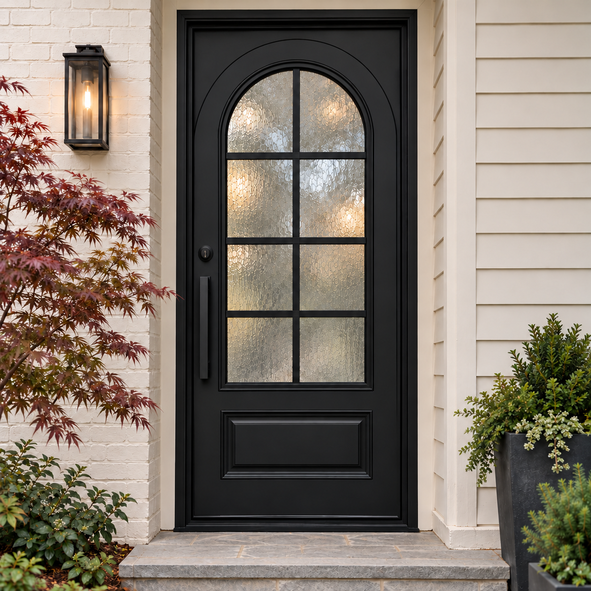 Front view of a black iron entry door with an arched textured glass panel and a rectangular lower panel.