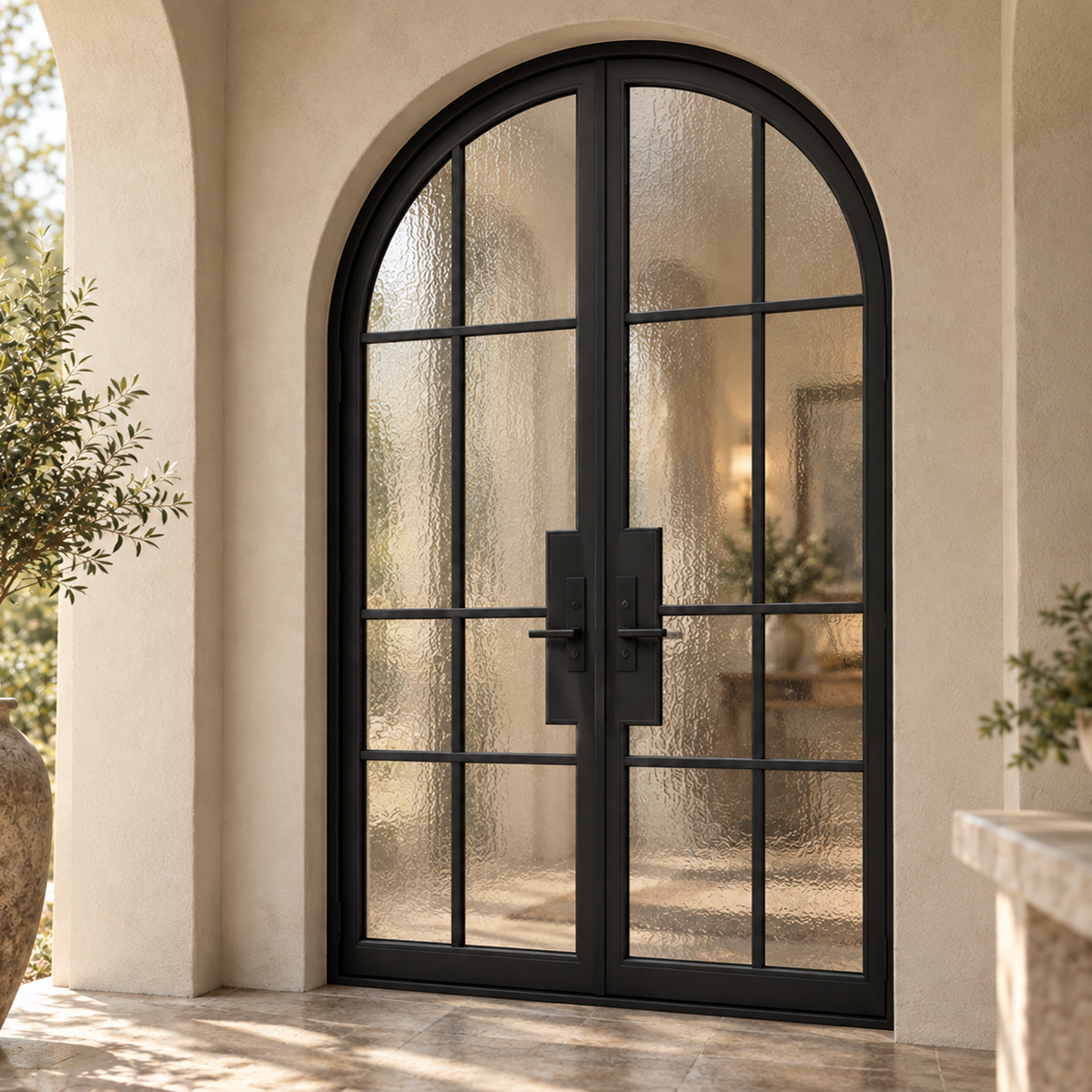 Black arched iron French doors with divided textured glass at an elegant Mediterranean style home entrance