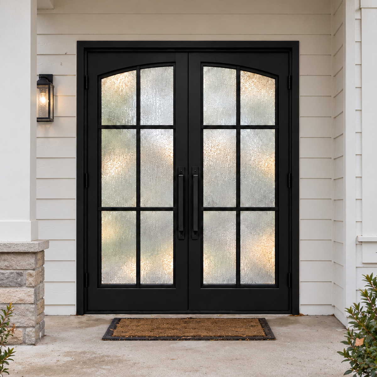 Black double modern iron door with textured glass and gently arched grid panels at a covered front porch