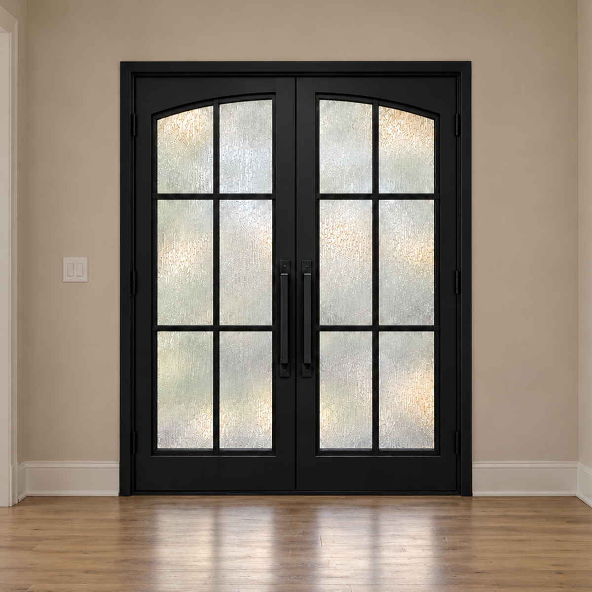 Interior entryway view of a black double modern iron door with textured glass and arched panel tops