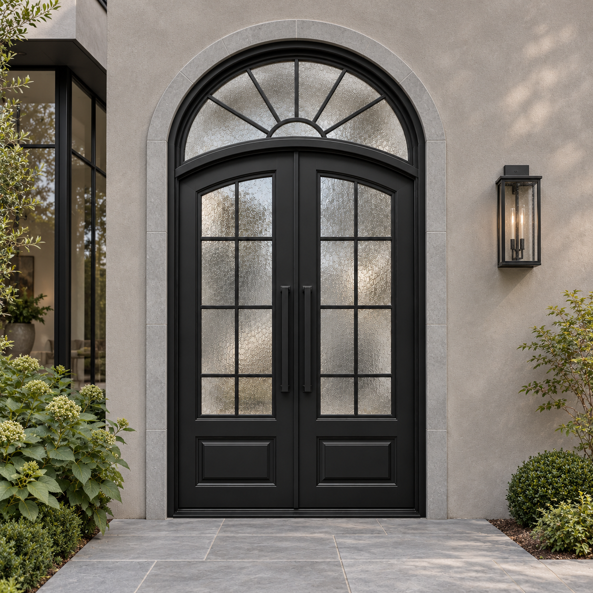 Black arched double traditional iron doors with a sunburst glass transom and divided textured glass in a stone-trimmed entrance