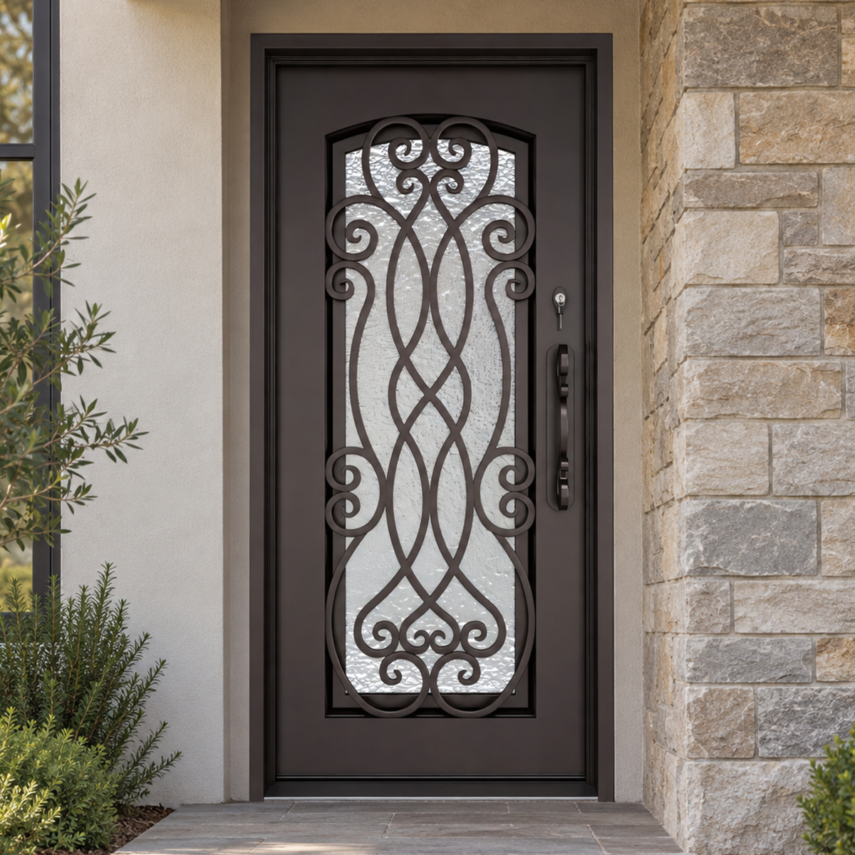 Traditional black iron entry door with woven scrollwork installed at an upscale American stone residence